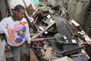 Morador olha destroços dos barracos que caíram após chuva de granizo